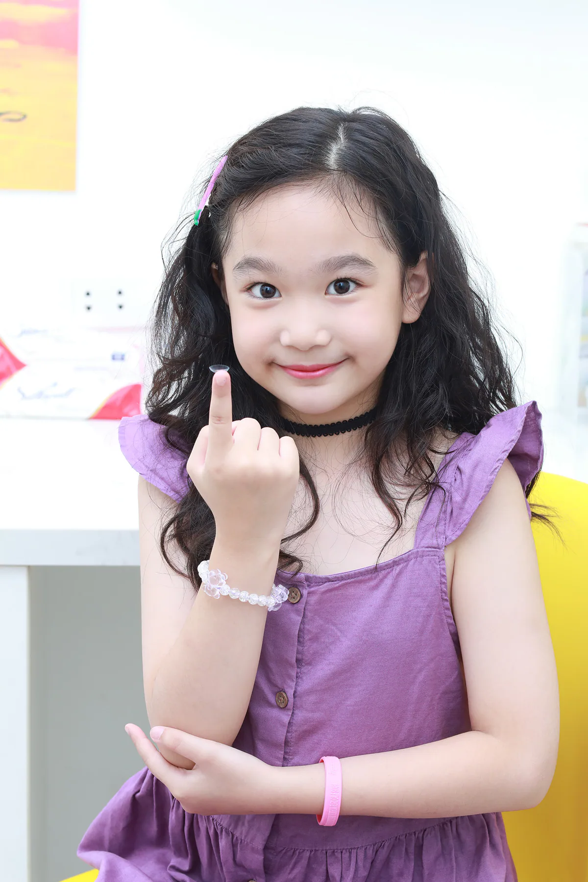 Bé cầm kính Ortho-K trên đầu ngón tay